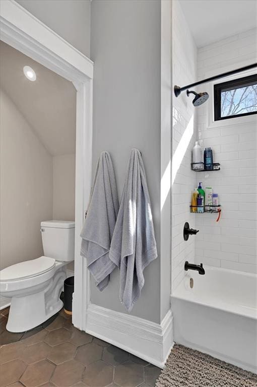 bathroom featuring bathing tub / shower combination, tile patterned flooring, toilet, and baseboards