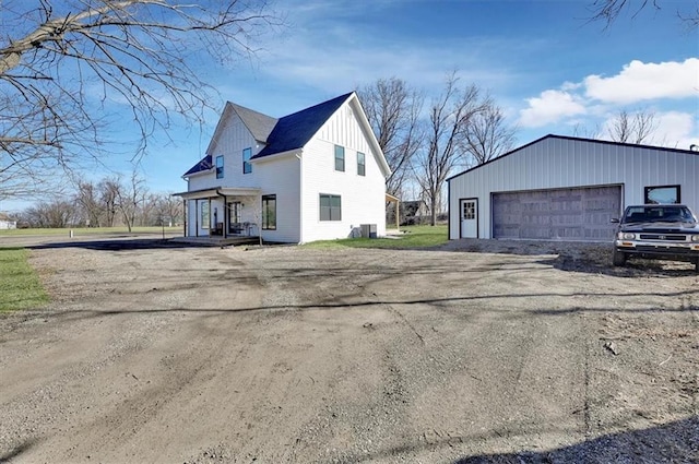 view of property exterior featuring board and batten siding, a detached garage, and an outdoor structure