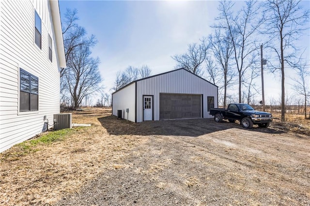 detached garage featuring central air condition unit and dirt driveway