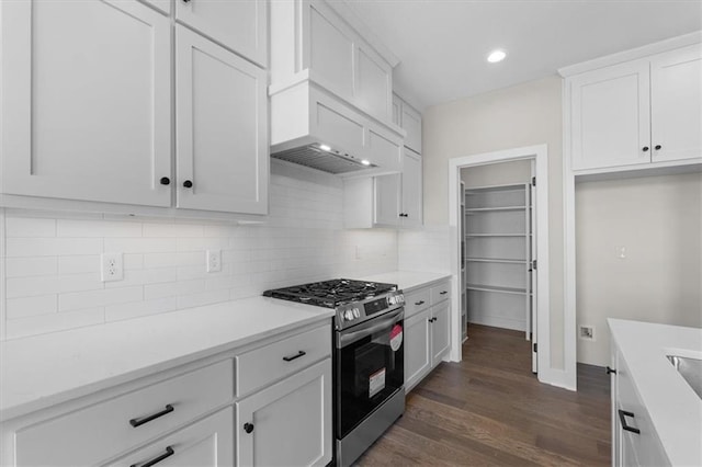 kitchen with stainless steel range with gas stovetop, dark wood-style floors, white cabinetry, and tasteful backsplash