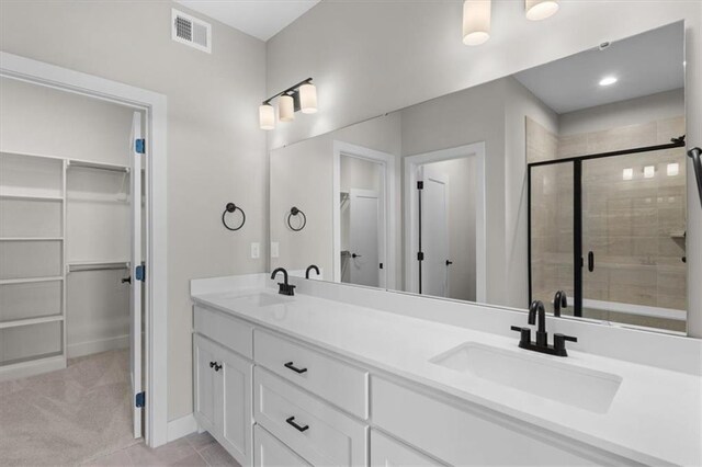 full bathroom featuring a spacious closet, visible vents, and a sink