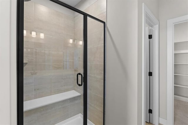 full bathroom featuring a walk in closet and a stall shower