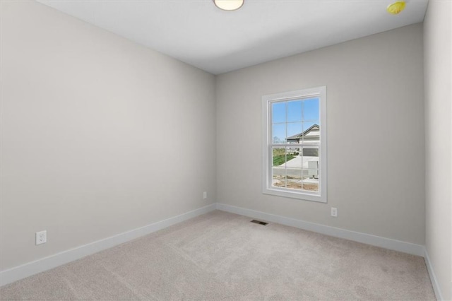 empty room with light carpet, visible vents, and baseboards