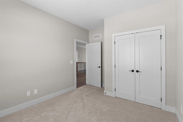 unfurnished bedroom featuring a closet, visible vents, carpet flooring, and baseboards