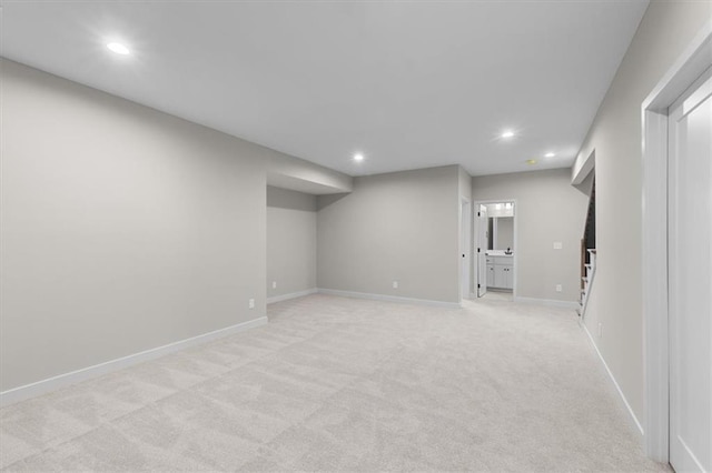 finished below grade area featuring recessed lighting, baseboards, and light colored carpet
