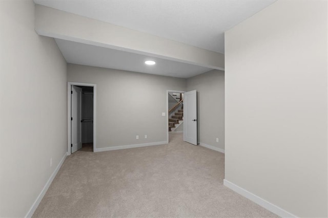 basement with light colored carpet, baseboards, stairs, and recessed lighting