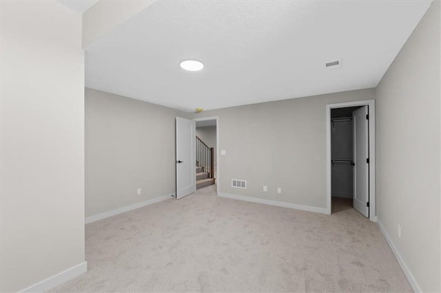 unfurnished bedroom with a spacious closet, carpet floors, and visible vents