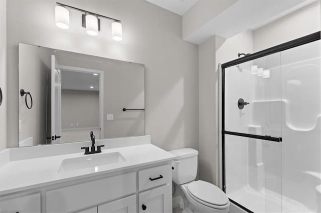 full bathroom featuring a shower stall, toilet, and vanity