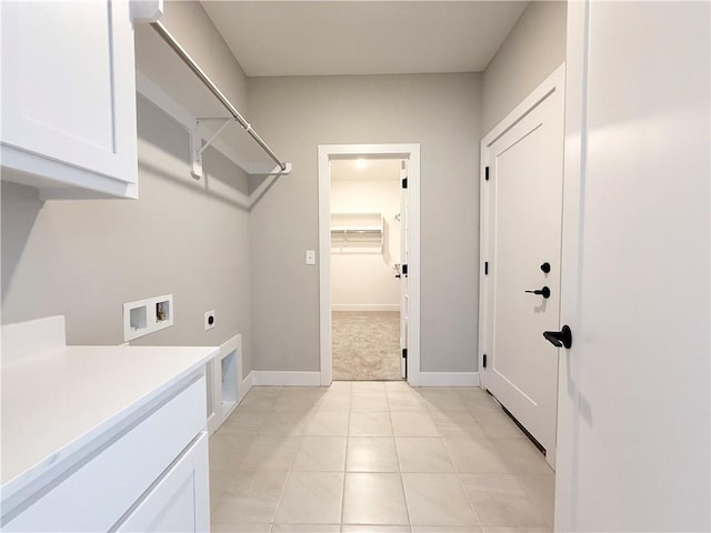 clothes washing area featuring washer hookup, cabinet space, electric dryer hookup, and baseboards