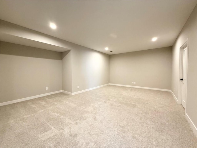 finished basement featuring recessed lighting, light colored carpet, and baseboards