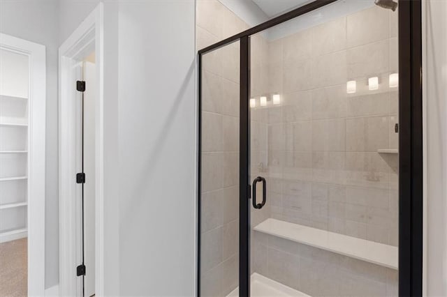 full bathroom with a walk in closet and a stall shower