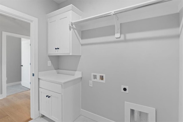 washroom with baseboards, hookup for a washing machine, light wood-style floors, cabinet space, and hookup for an electric dryer