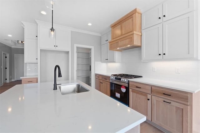 kitchen featuring tasteful backsplash, a sink, light countertops, stainless steel gas range, and recessed lighting