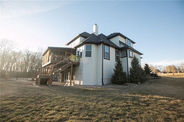 view of property exterior with stairs, a lawn, a chimney, and a sunroom