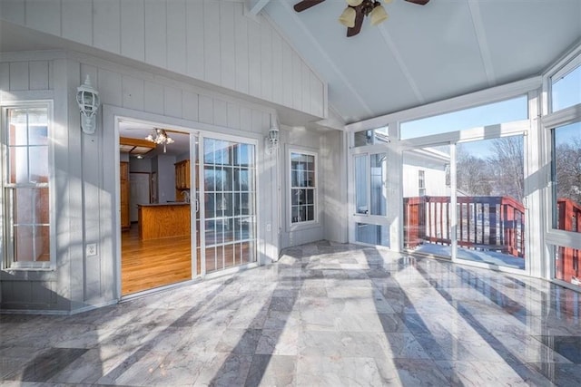 unfurnished sunroom with lofted ceiling and a ceiling fan