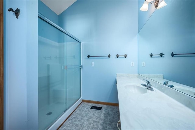 full bathroom featuring a shower stall, vanity, and baseboards