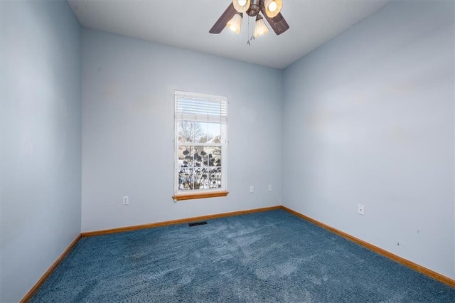 carpeted spare room with visible vents, ceiling fan, and baseboards