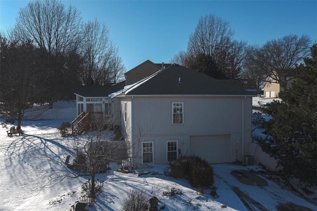 view of snowy exterior featuring an attached garage