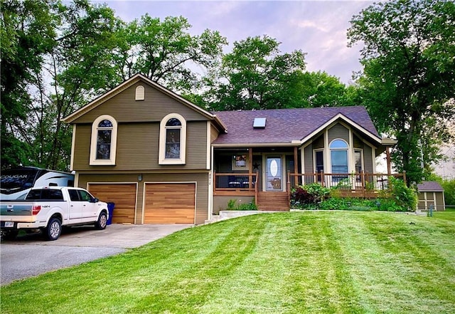 split level home featuring roof with shingles, a porch, an attached garage, a front yard, and driveway