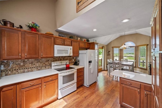 kitchen with white appliances, tasteful backsplash, brown cabinetry, vaulted ceiling, and light wood-type flooring