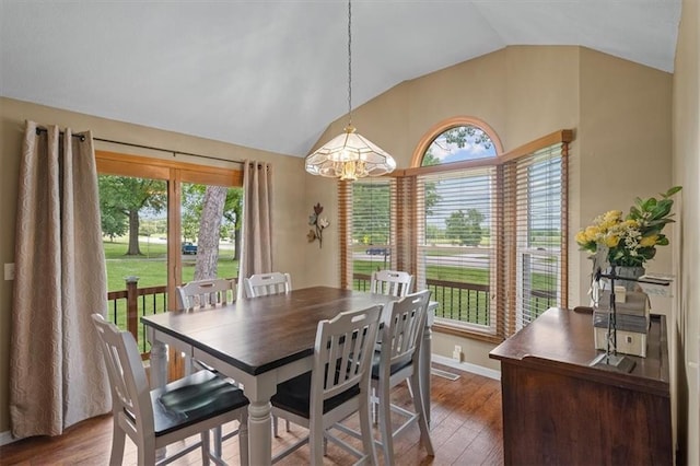 dining area featuring baseboards, vaulted ceiling, and wood finished floors