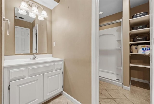 bathroom with baseboards, tile patterned flooring, walk in shower, vanity, and a chandelier