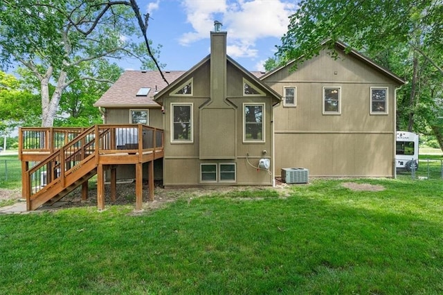 rear view of house featuring a chimney, a lawn, central AC unit, a deck, and stairs