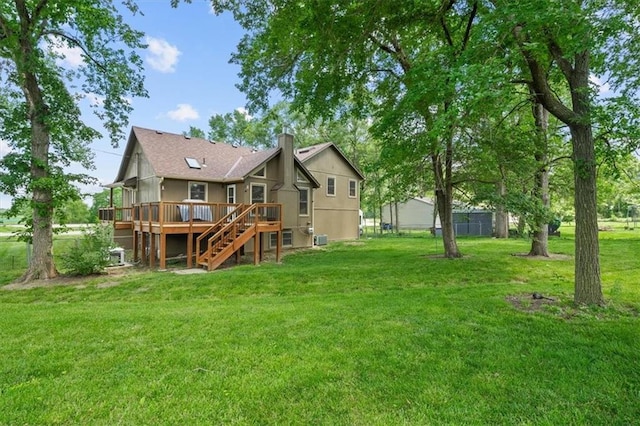 rear view of property featuring a wooden deck, a chimney, stairway, and a yard