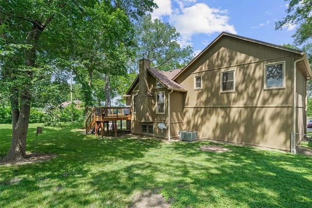 back of property featuring cooling unit, stairway, a lawn, a wooden deck, and a chimney