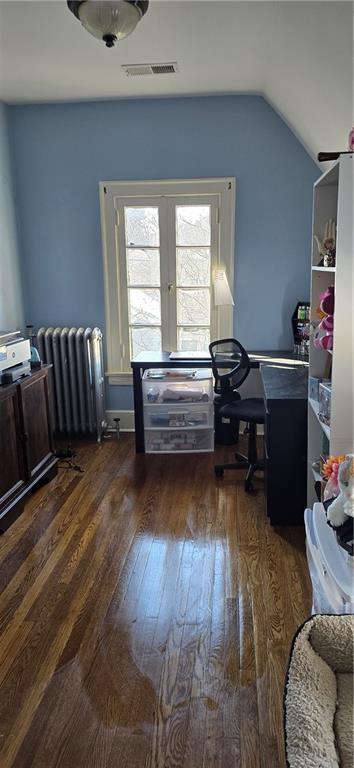 office space with lofted ceiling, dark wood-type flooring, visible vents, french doors, and radiator heating unit