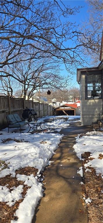 yard covered in snow featuring fence