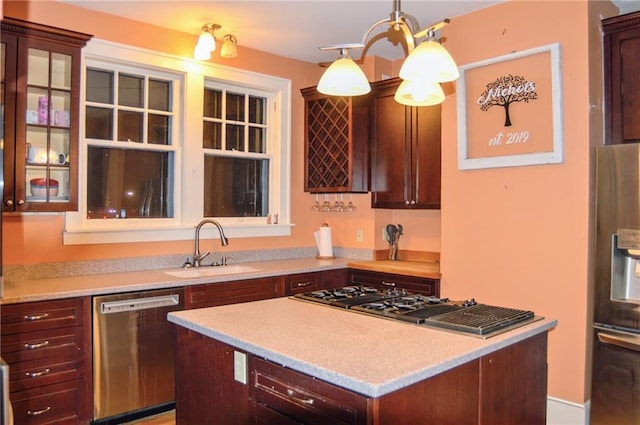 kitchen with a sink, pendant lighting, stainless steel appliances, and light countertops