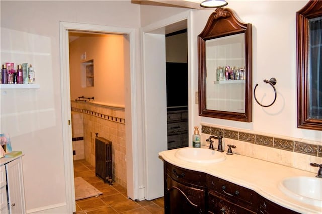 bathroom with double vanity, tile walls, a sink, and tile patterned floors