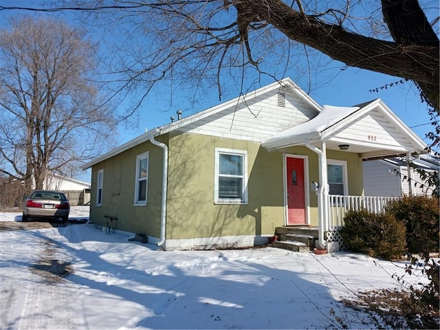 bungalow-style house with a porch and stucco siding