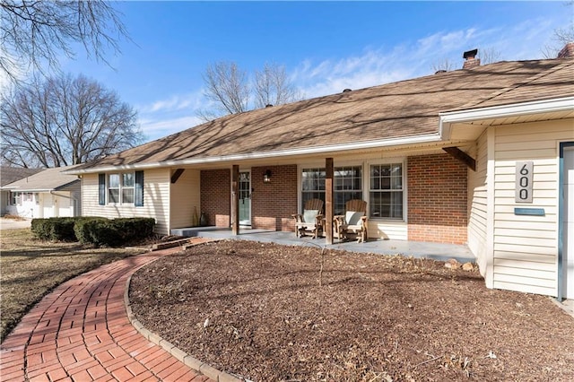 view of front of property featuring covered porch and brick siding