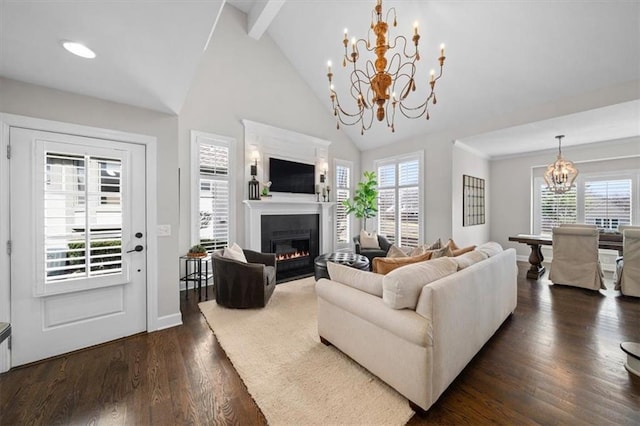 living room featuring dark wood-style floors, plenty of natural light, an inviting chandelier, and a glass covered fireplace