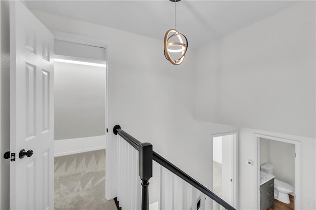 corridor featuring carpet flooring and an upstairs landing