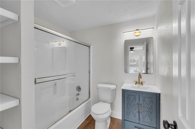 full bathroom featuring toilet, shower / bath combination with glass door, wood finished floors, vanity, and baseboards