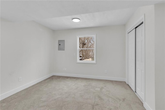 unfurnished bedroom featuring a closet, electric panel, baseboards, and carpet flooring