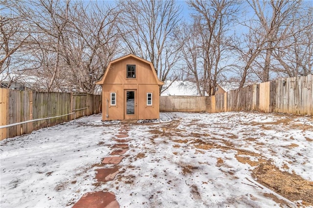 snow covered structure with an outbuilding and a fenced backyard