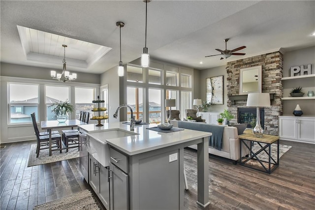 kitchen featuring a kitchen island with sink, light countertops, decorative light fixtures, and open floor plan