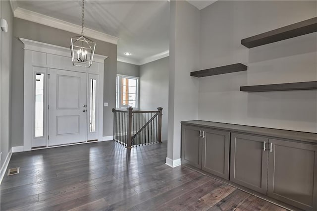 entrance foyer with baseboards, dark wood-type flooring, visible vents, and crown molding