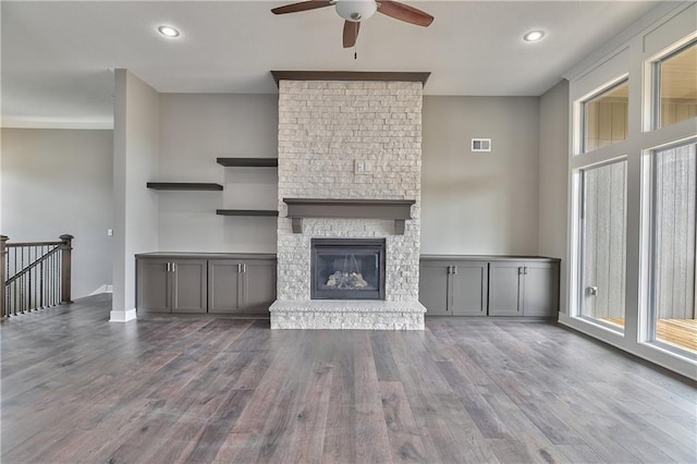 unfurnished living room featuring a fireplace, visible vents, wood finished floors, and recessed lighting