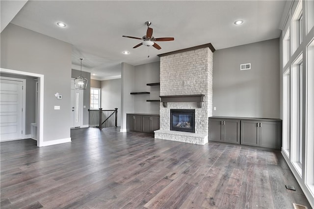 unfurnished living room featuring a fireplace, dark wood finished floors, and recessed lighting