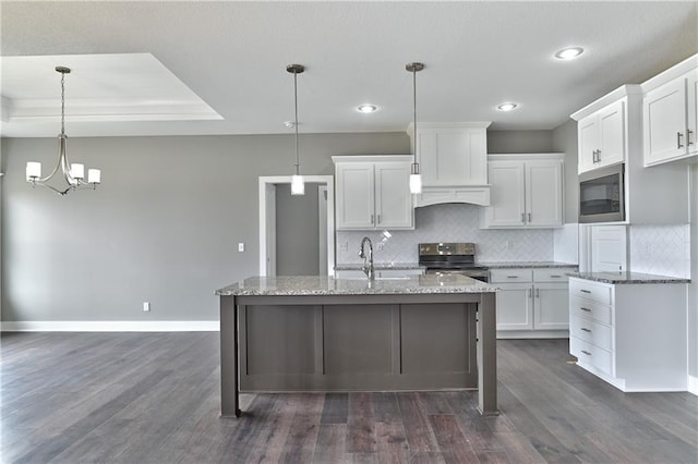 kitchen featuring appliances with stainless steel finishes, white cabinetry, and light stone counters