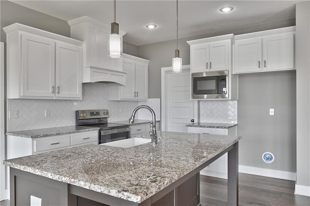 kitchen featuring built in microwave, white cabinets, decorative light fixtures, and stainless steel electric range