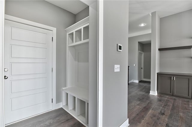 mudroom with dark wood-style flooring and baseboards