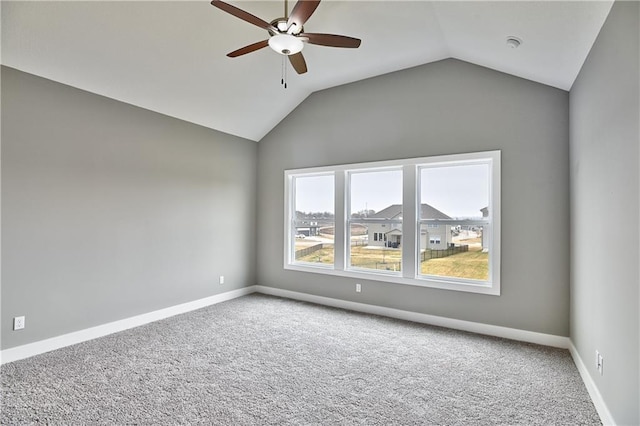 spare room featuring lofted ceiling, ceiling fan, carpet, and baseboards