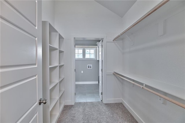 walk in closet featuring carpet and vaulted ceiling