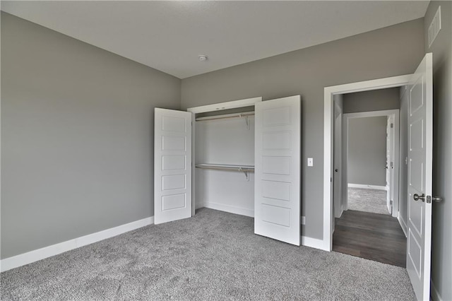 unfurnished bedroom with carpet, a closet, visible vents, and baseboards